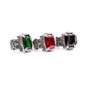 Macro detail of three vintage men's rings with red, green and black gemstone insets