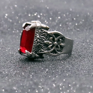Macro shot of retro stainless steel ring with rectangle red gemstone and embossed cross patterns