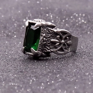 Detailed side view of vintage dragon claw ring holding a rectangular green gemstone