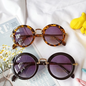 Detail of round kids sunglasses with leopard and black frames plus UV400 gradient lenses