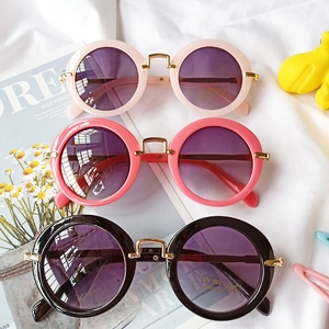 Detail view of round kids' UV400 sunglasses with stylish gold metal bridge accents