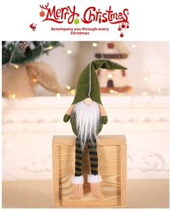 Detail of Christmas gnome plush with green pointed hat and striped legs on wooden box