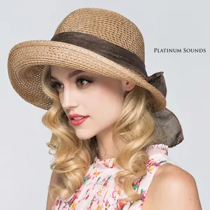 Summer straw sun hat with brown ribbon bow and foldable wide brim for stylish sun protection