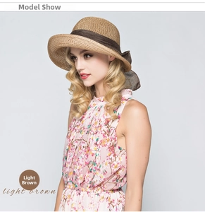 Detail of light brown straw sun hat with elegant dark brown ribbon bow decoration