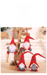 Gnomes de Noël en peluche avec bonnets pointus et barbes blanches sur une étagère en bois