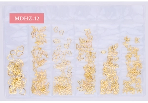 Macro detail of 6-grid box containing golden metal nail art studs in celestial shapes