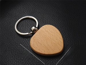 Detail of a 40x40mm rounded triangular beech wood keychain with natural grain on leather