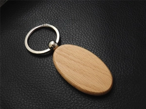 Macro detail of oval beech wood keychain with smooth texture and silver metal ring