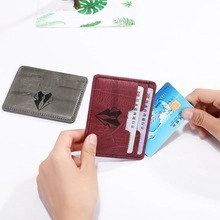 Detail showing slim card slots and leather texture of gray and burgundy wallets