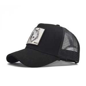 Detailed macro view of the embroidered wolf patch on a black mesh trucker baseball hat