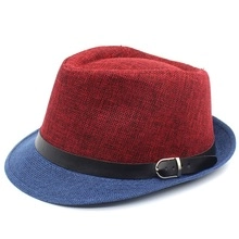 Close-up of contrast-colored sun hat with red crown, blue brim, and black leather belt buckle