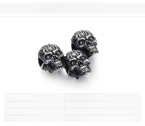 Detailed macro view of three vintage stainless steel skull pendants with engraved textures