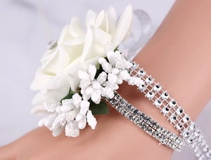 Close-up of white silk rose wrist corsage with sparkling crystal rhinestones and pearls