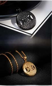 Macro detail of Tree of Life pendants in black and gold finish with Celtic knot textures