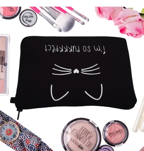 Flat-Lay-Ansicht der schwarzen Kosmetiktasche mit Katzenprint und diversen Schminkutensilien