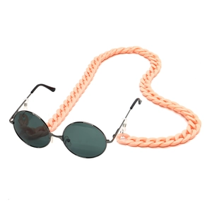 Close-up of pink acrylic eyewear chain curved in a heart shape with black round sunglasses