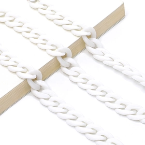 Macro detail of white acrylic chunky chain links arranged on a book for accessories