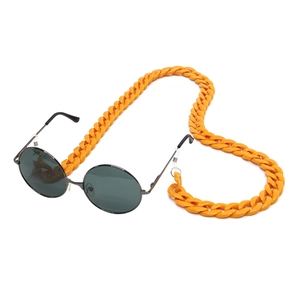 Fashionable round sunglasses with orange acrylic chunky chain strap on white background