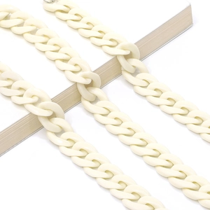 Close-up of ivory acrylic chain strap on a white book with minimalist styling