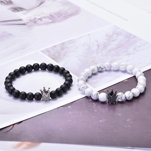 Détail de bracelets de couple en pierre mate et turquoise blanche avec couronnes de zircon