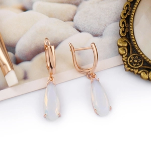 Dettaglio degli orecchini a goccia con pietra bianca e ganci in oro rosa in stile vintage