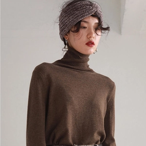Detail of twisted grey knit headband and brown turtleneck sweater for winter warmth
