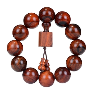 Bracelet bouddhiste en bois de rose avec pendentifs calebasse sur fond blanc pur