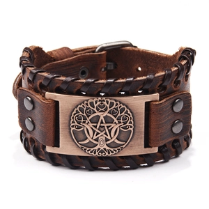 Detail of a brown leather wristband with a bronze tree of life and pentagram plaque