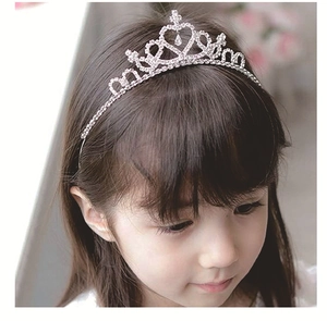 Close-up of a silver heart crown headband with sparkling rhinestones on a child model