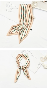Detail of silk scarf with beige stripes and stirrup pattern tied in a stylish bow
