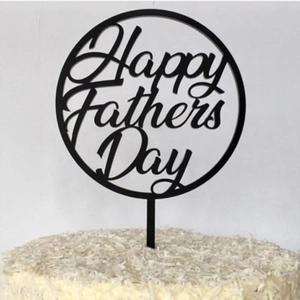 Detail shot of black Happy Fathers Day acrylic cake topper on a white coconut cake