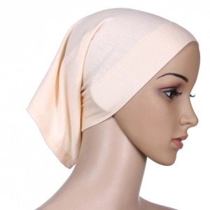 Detailed side view of a soft, elastic light beige under-turban cap on a mannequin