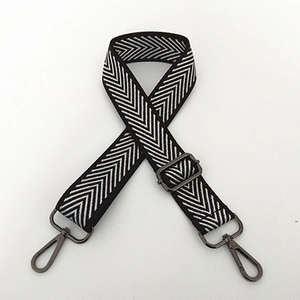 Detail of adjustable black and white woven nylon strap with metal buckle and hook clasp