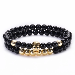 Bracciale a doppio strato in agata nera con ciondolo a teschio dorato e dettagli metallici