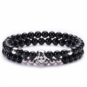 Dettaglio del set di bracciali in onice nero con ciondolo a teschio e sfere argentate