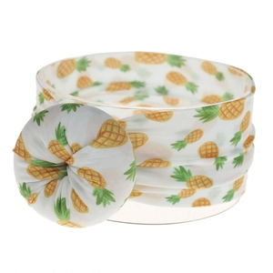 Detalle de diadema de nailon blanca con estampado de piña amarilla y nudo donut