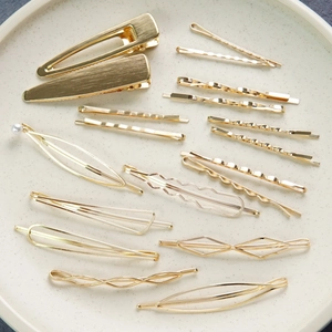 Eleganter goldener Haarspangen-Set mit Perlen und geometrischen Formen auf einem Teller