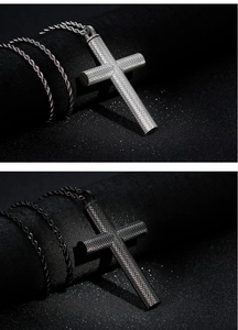 Detailed shot of cross pendants in silver and black with diamond pattern on black fabric