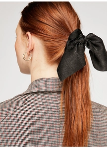Elegant back view of woman wearing a black satin bow scrunchie with long ribbons