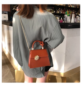 Caramel retro small square bag with chain strap and knot handle shown on a model