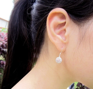 Macro side view of 925 sterling silver shambhala crystal ball drop earrings on model