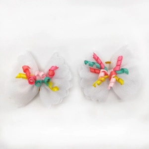 Detail of white lace pet hair bows with colorful spiral ribbons and elastic bands