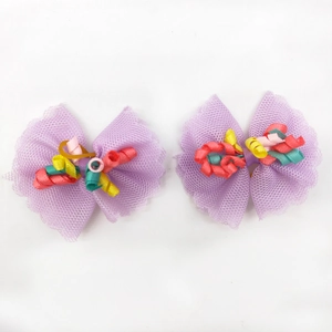 Detail of light purple lace hair bow clips with colorful curly ribbons for small dogs