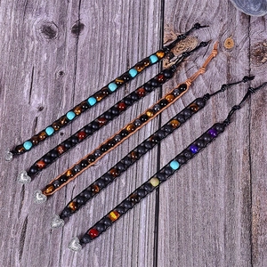 Detail of colorful lava stone and tiger eye beads on woven leather wrap bracelets