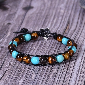 Close-up of tiger eye and turquoise beads on a leather wrap bracelet with heart clasp