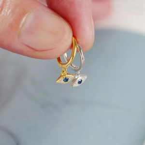 Macro detail of S925 sterling silver evil eye hoop earrings with blue zircon inlays