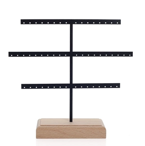 Three-tier black metal earring holder stand with a sturdy rectangular wooden base