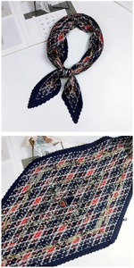 Détail d'un foulard plissé en soie avec motifs floraux géométriques en bleu marine