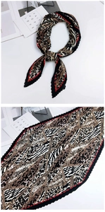 Gros plan d'un foulard en soie plissé avec motif léopard et rayures géométriques rouges