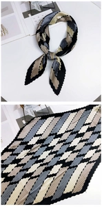 Détail d'un foulard plissé avec motif géométrique en losange et bords en zigzag